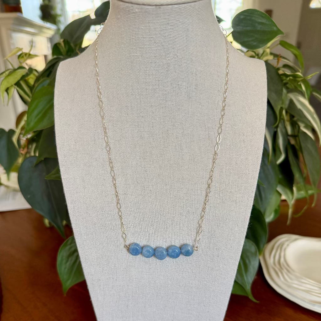 blue beaded chain necklace on a bust
