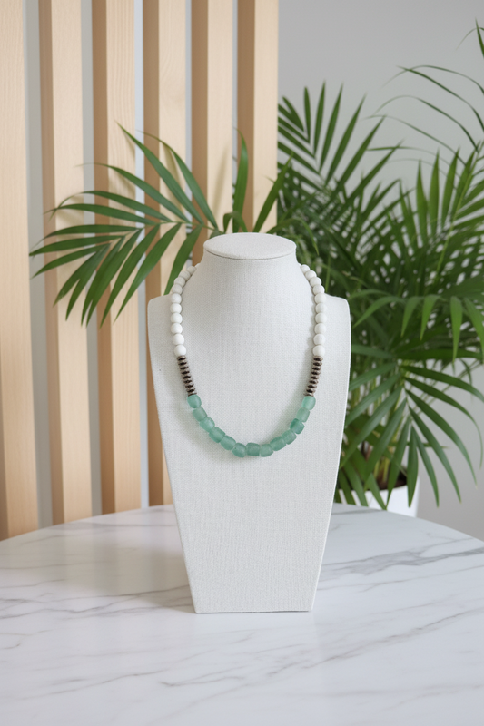 African Glass Beaded Necklace on a bust with a white countertop and slated wood background