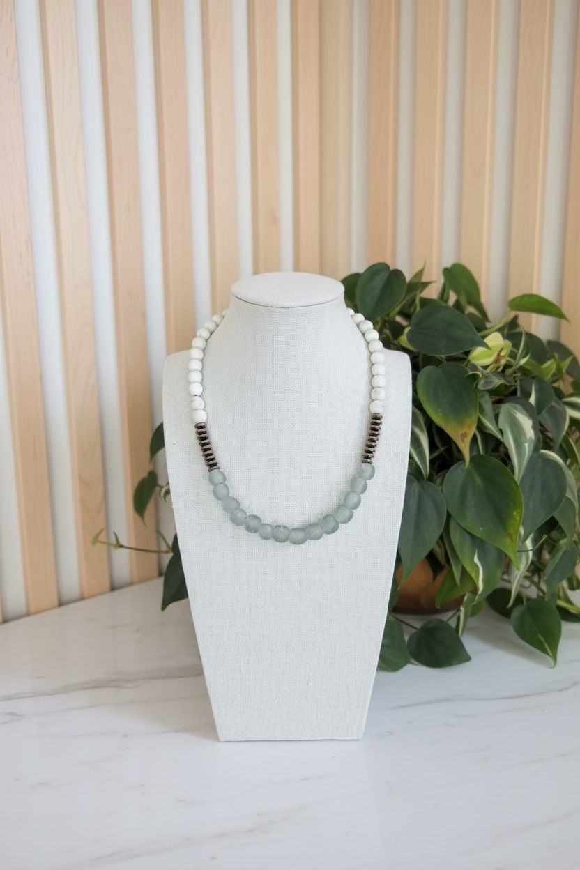 African glass bead ecklace on a mannequin bust with a blurred indoor background