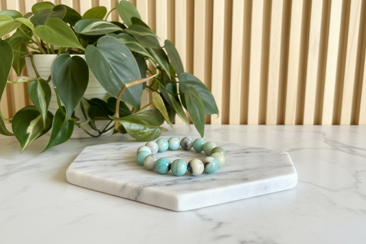 Amazonite beaded bracelet on a white counter with a plant in the background