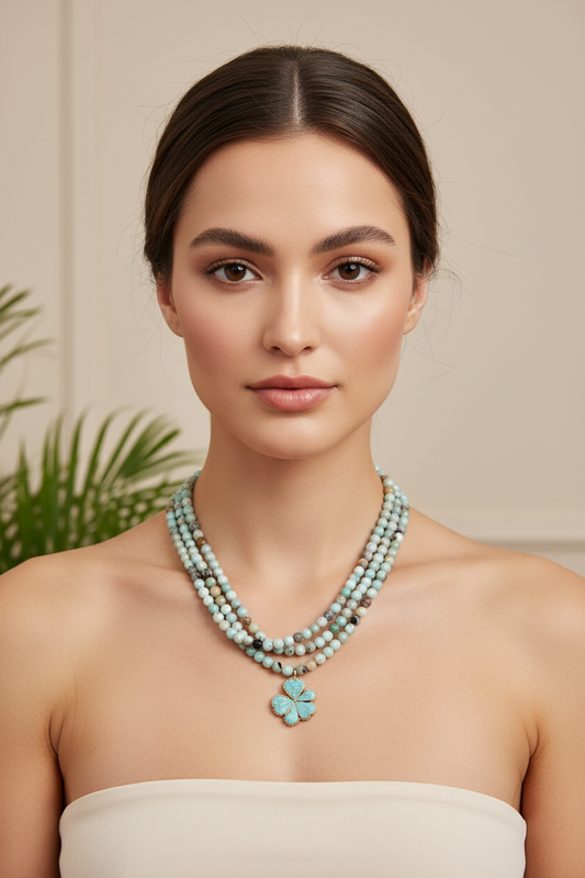 A multi-strand beaded necklace with a flower pendant on a model