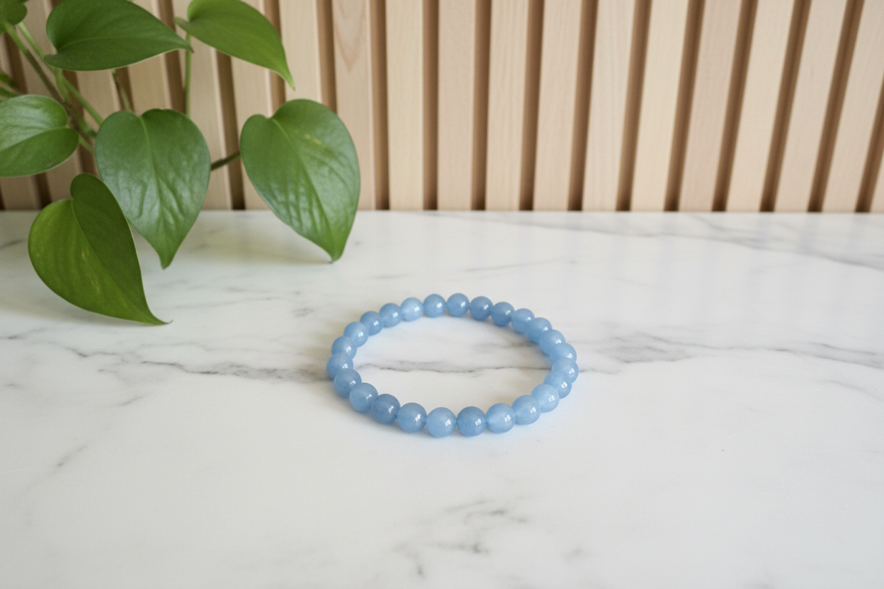 Blue beaded bracelet on a white counter with a plant in the background