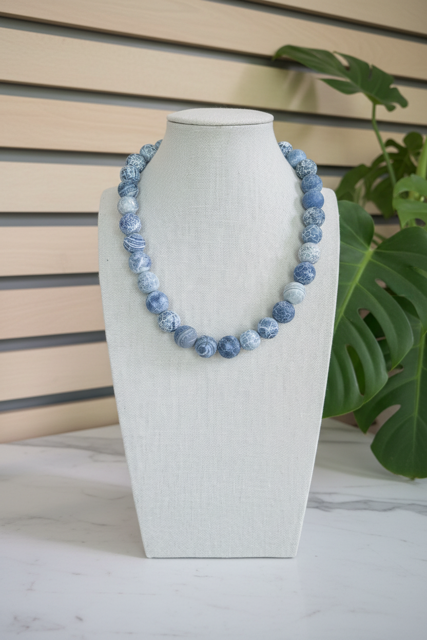 Blue Crackle Necklace on a white countertop with a slated wood background