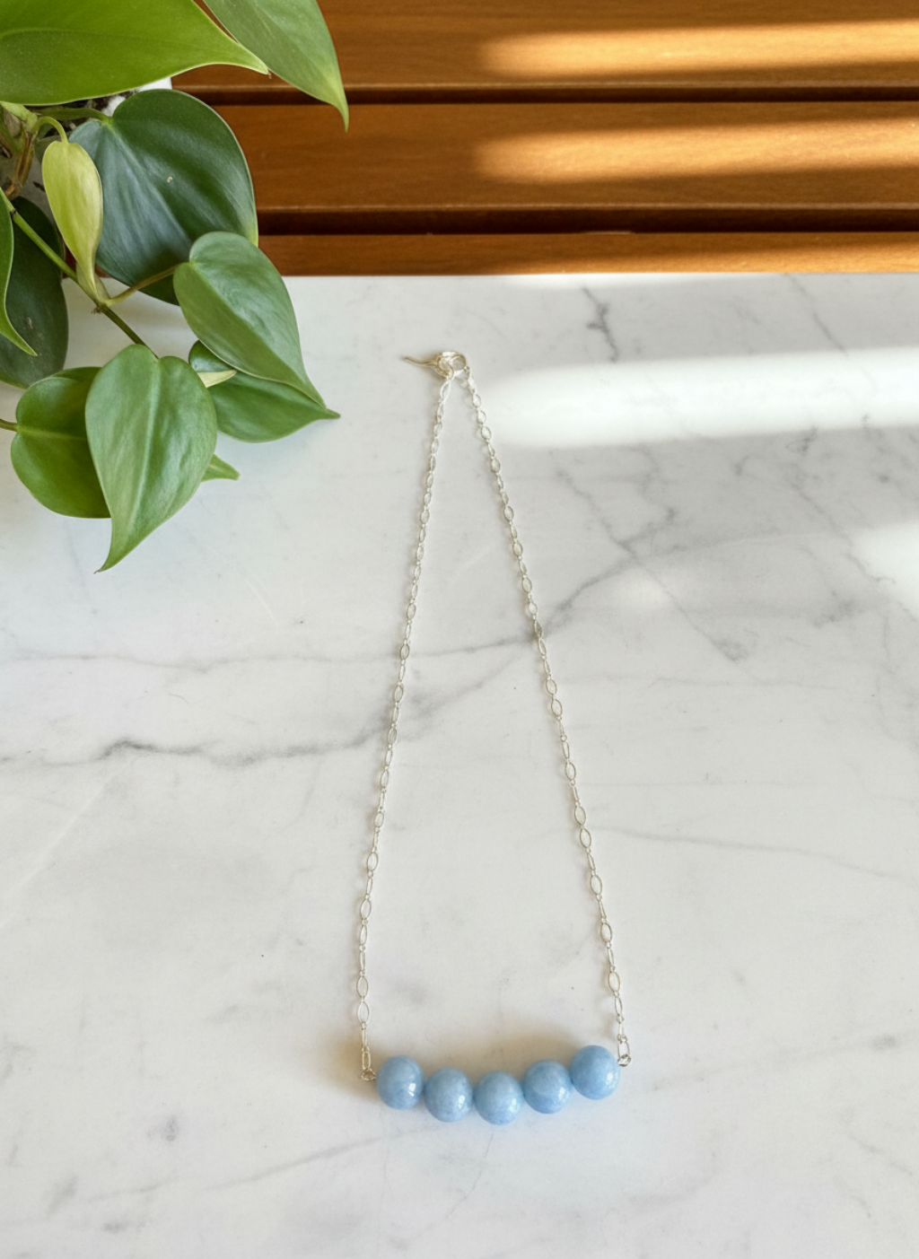 blue beaded necklace on a white counter