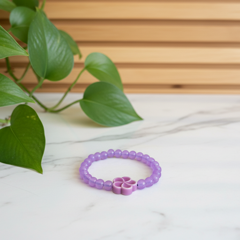 Purple bracelet on a white counter with a plant in the background