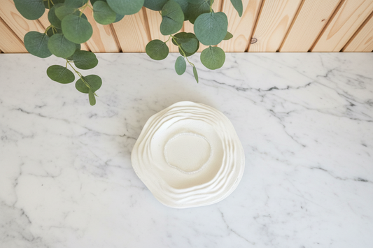 Clear bracelet on a white counter with a plant in the background