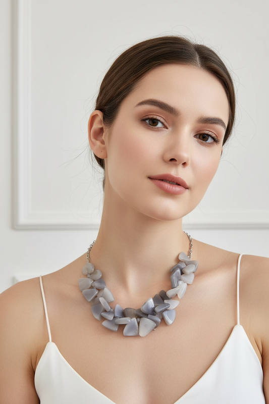 A chunky statement necklace made of irregular chalcedony beads on a model