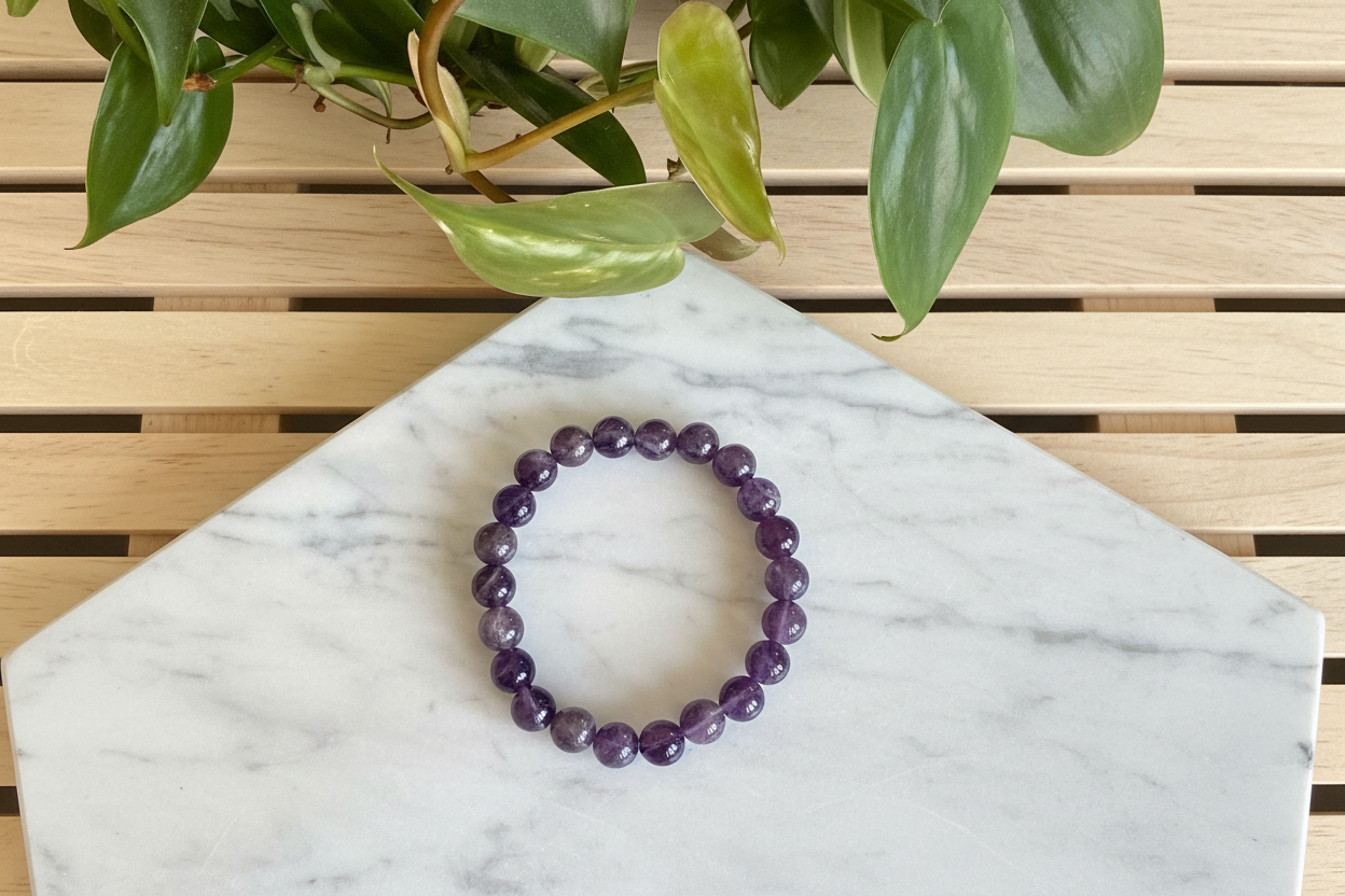Purple beaded bracelet on a white counter with a plant in the background