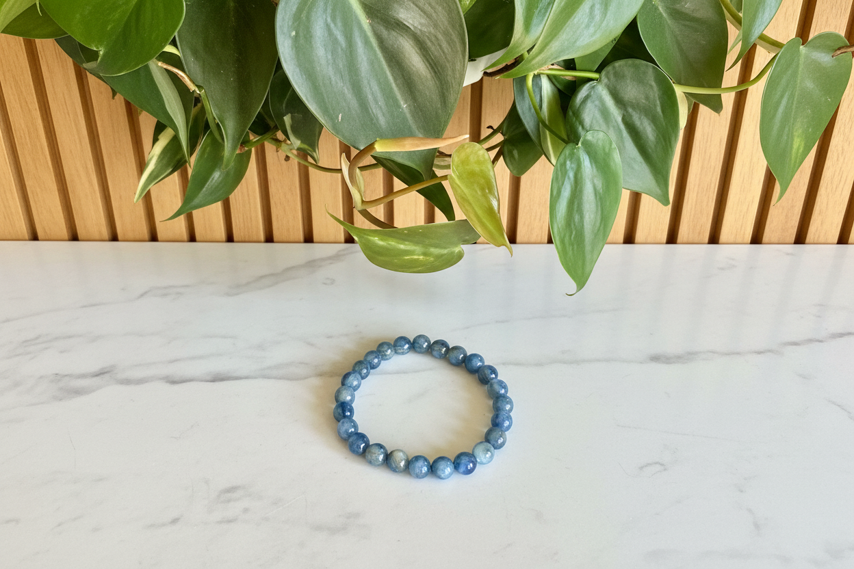 Kyanite blue beaded bracelet on a white counter with a plant in the background