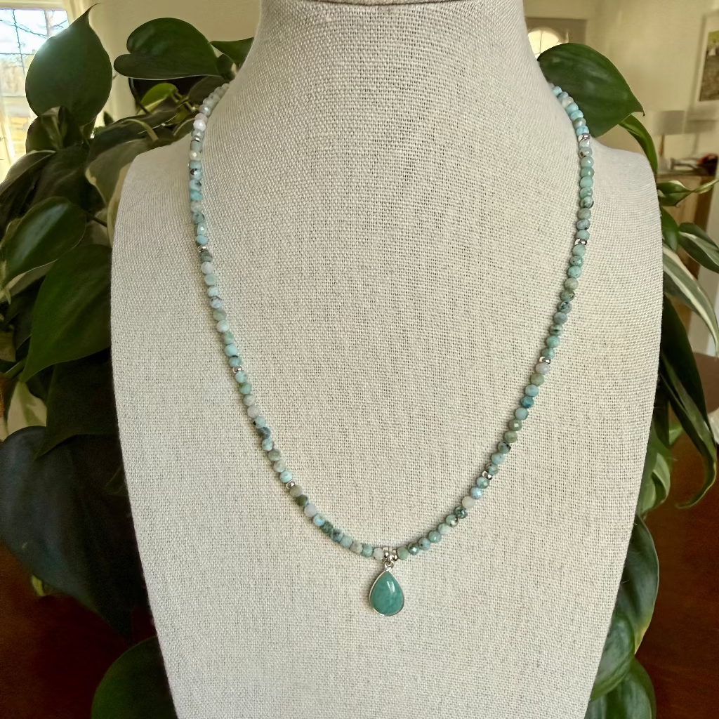 Necklace with a pendant on a mannequin bust in a home setting