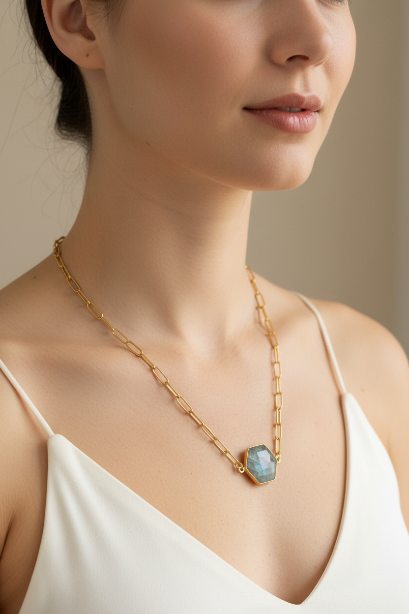 Gold chain necklace with a hexagonal pendant on a model