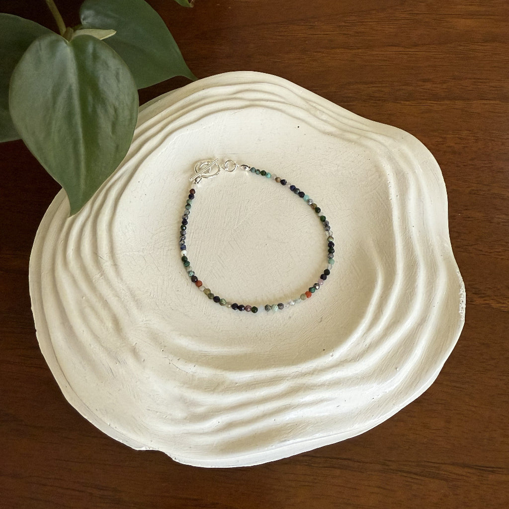 Bracelet on a white shell with a wooden background