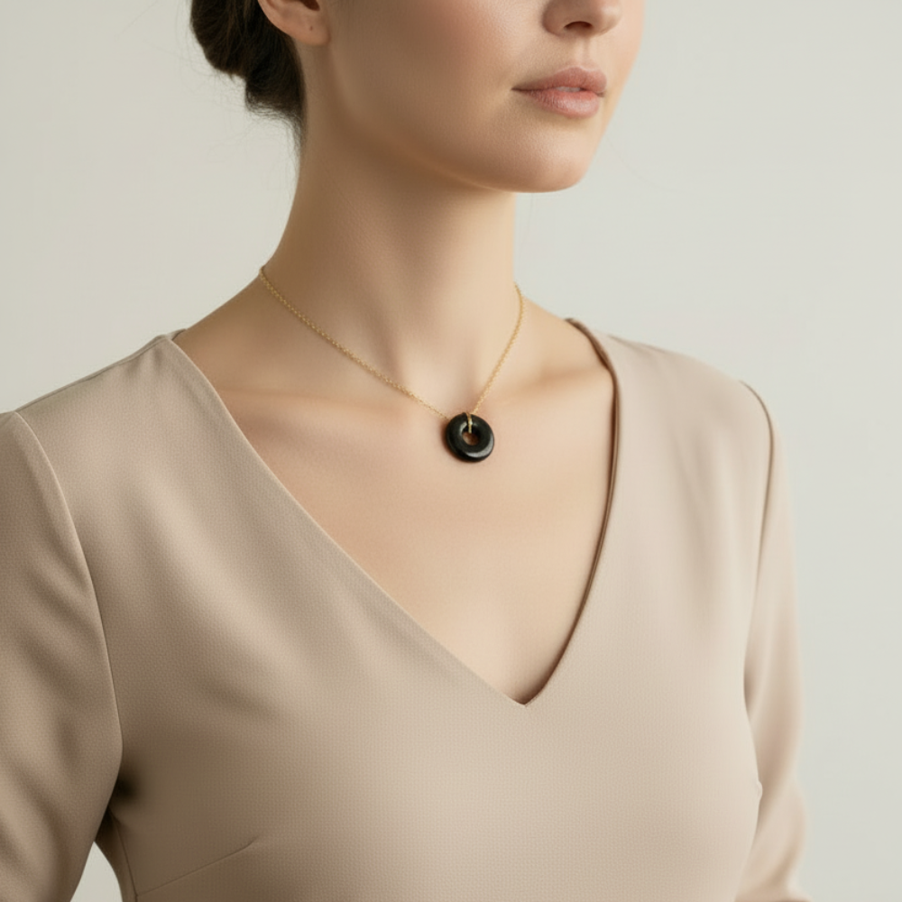 Necklace with a dark green jade pendant on a model with a plain background