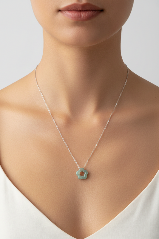Necklace with a green jade flower pendant on a model with a plain background