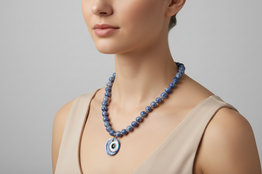 Necklace with blue and white beads and a ceramic charm on a model