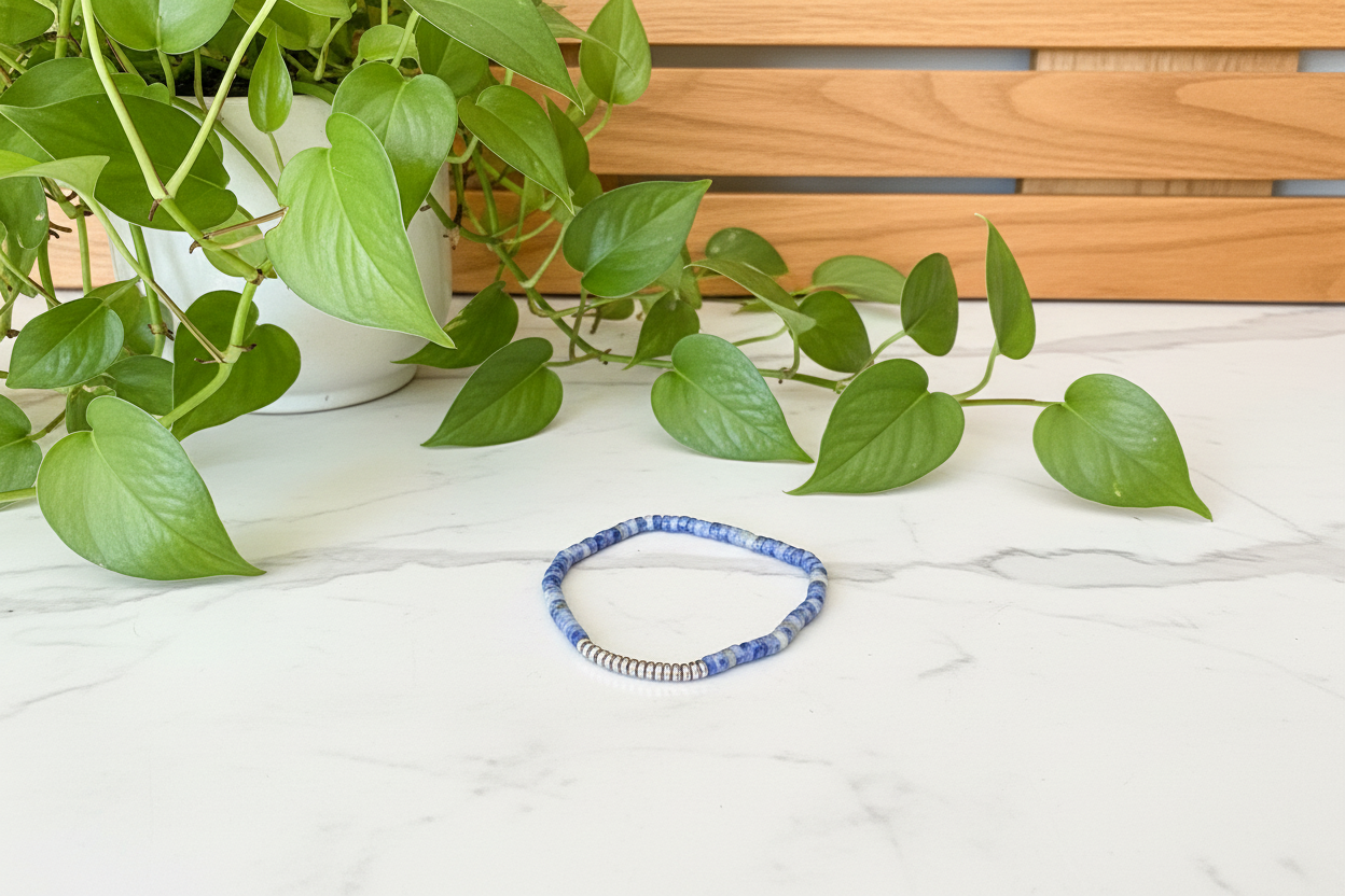 blue beaded bracelet on a white counter with a plant in the background