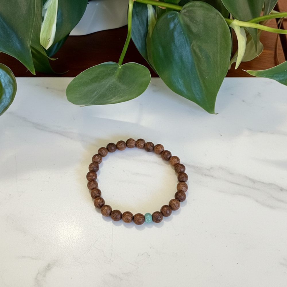 Bracelet on a marble counter with green leaves in the background